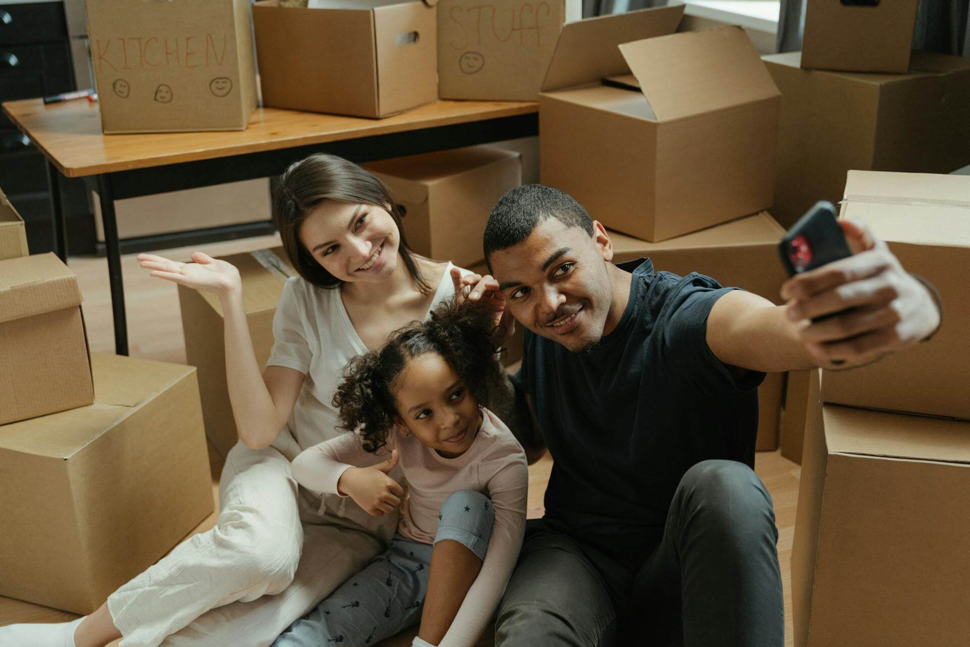 Smiling Family With Boxes Thumbs Up